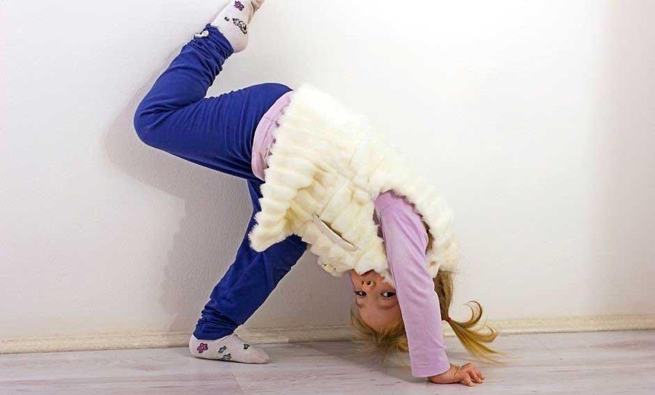 young girl trying to stand on head